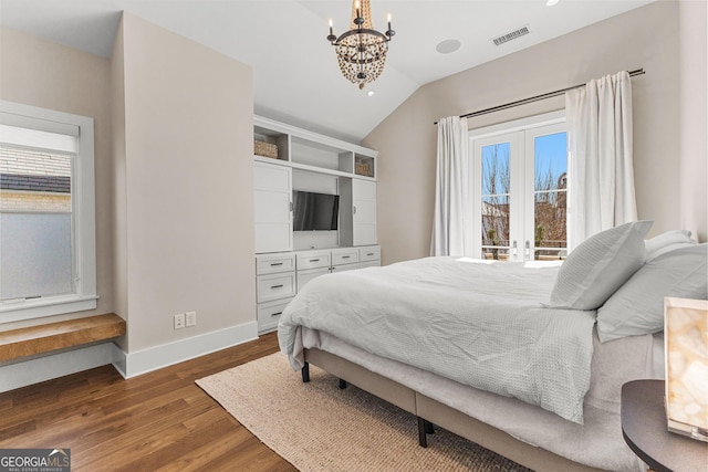 bedroom with lofted ceiling, a chandelier, dark wood-type flooring, visible vents, and baseboards