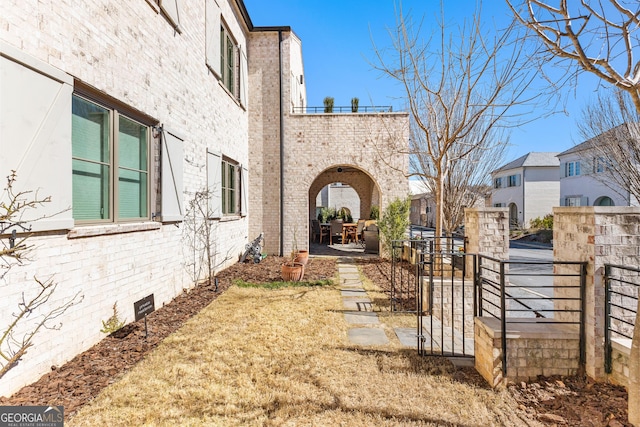 exterior space featuring a patio area, crawl space, brick siding, and fence