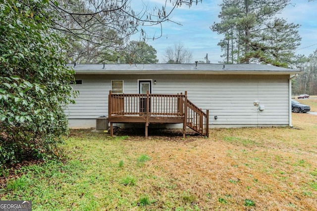 back of property featuring a deck, a lawn, and central air condition unit