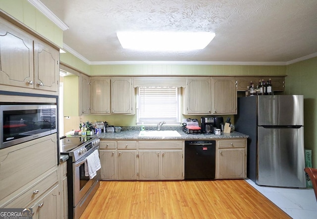 kitchen featuring appliances with stainless steel finishes, light wood-type flooring, a sink, and ornamental molding