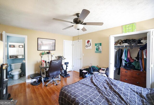 bedroom featuring a closet, ensuite bathroom, ceiling fan, a textured ceiling, and wood finished floors