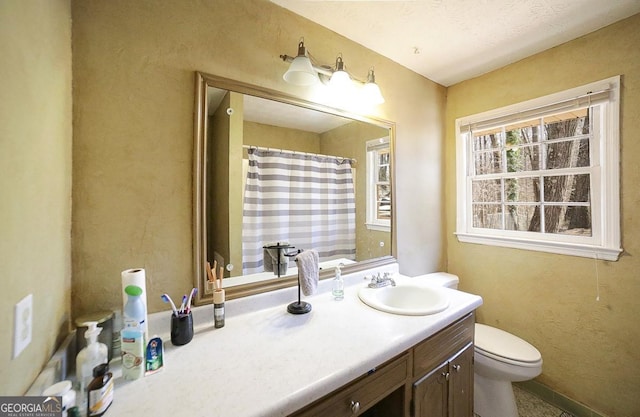 bathroom featuring a shower with shower curtain, vanity, and toilet