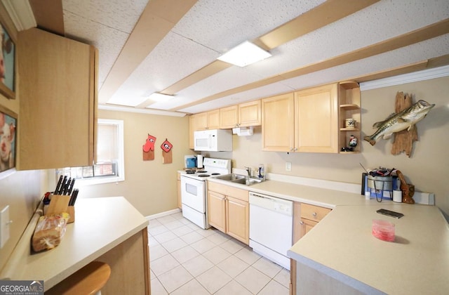 kitchen featuring white appliances, light brown cabinets, light countertops, and a sink