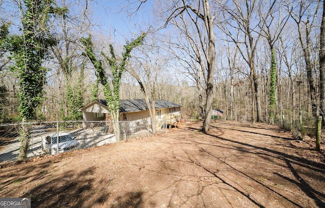 view of yard with fence and a view of trees