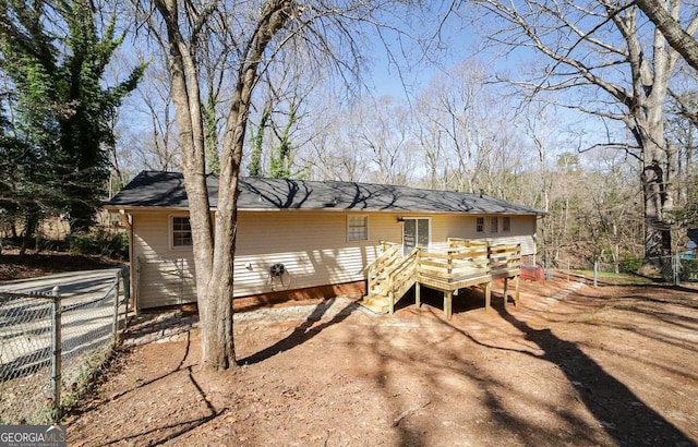 rear view of property with fence and a deck