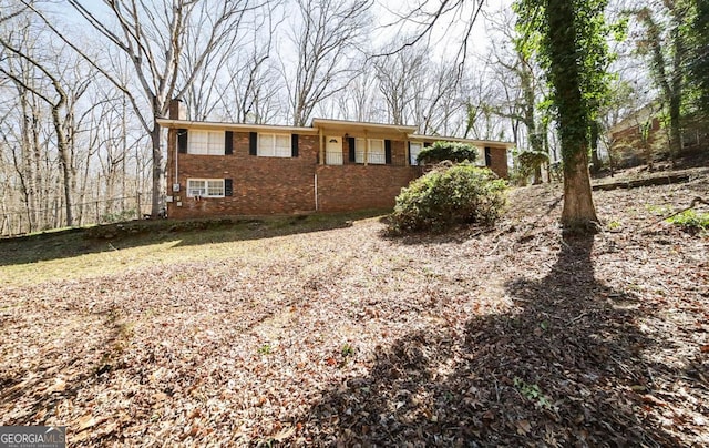 view of front of property featuring brick siding and a chimney