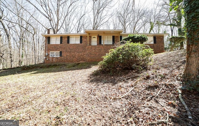 ranch-style house featuring brick siding and a chimney