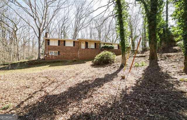 view of side of property with brick siding and a chimney