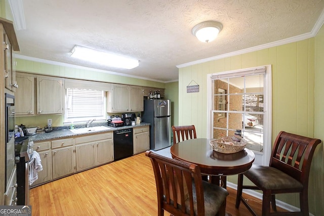 kitchen with light wood finished floors, black dishwasher, ornamental molding, freestanding refrigerator, and a sink