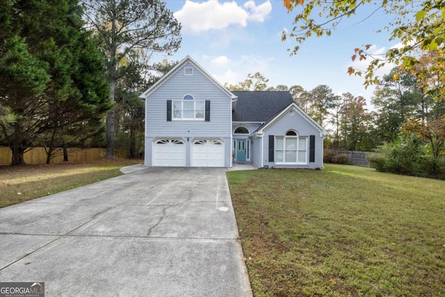 view of front of house with driveway, a garage, fence, and a front yard