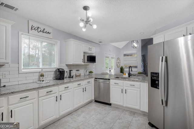 kitchen featuring visible vents, backsplash, appliances with stainless steel finishes, white cabinetry, and a sink