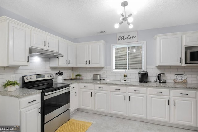 kitchen with light stone counters, under cabinet range hood, visible vents, white cabinets, and appliances with stainless steel finishes