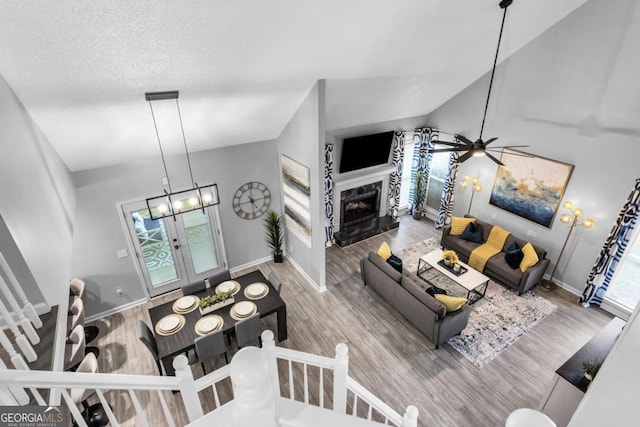 living area featuring vaulted ceiling, a fireplace, wood finished floors, and baseboards