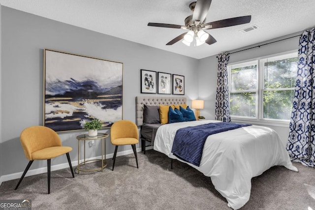 bedroom featuring baseboards, carpet, visible vents, and a textured ceiling