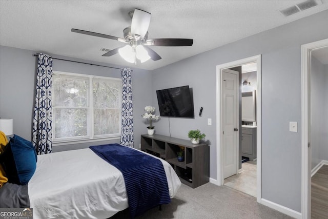 carpeted bedroom featuring a textured ceiling, visible vents, and baseboards