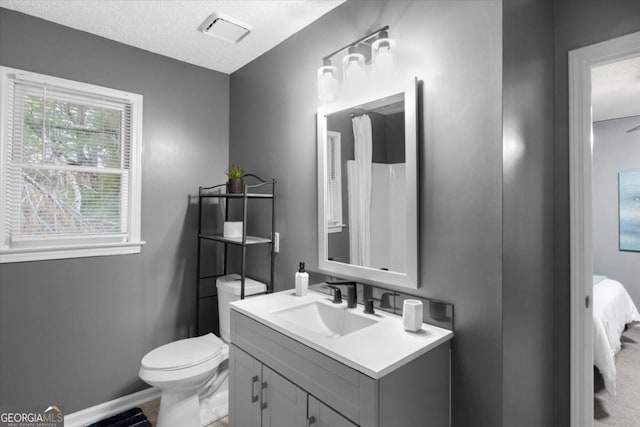 bathroom with visible vents, baseboards, toilet, a textured ceiling, and vanity