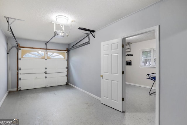 garage featuring a garage door opener and baseboards