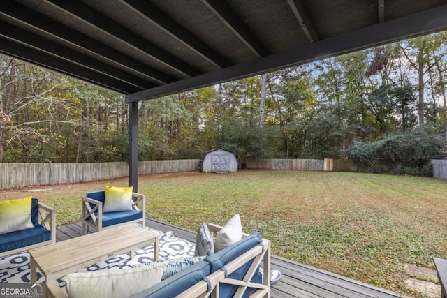 view of yard featuring a shed, a deck, a fenced backyard, and an outbuilding