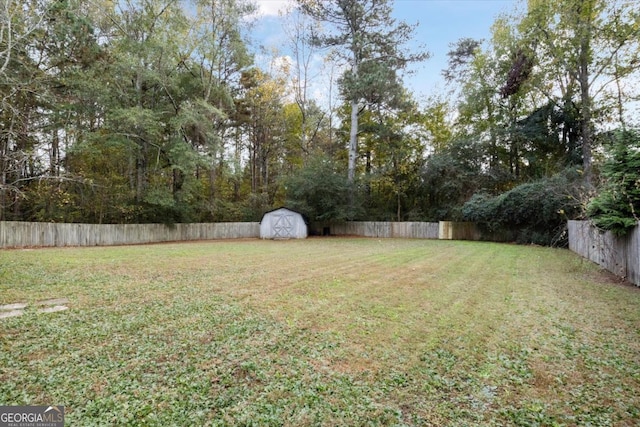 view of yard with an outbuilding, a shed, and a fenced backyard