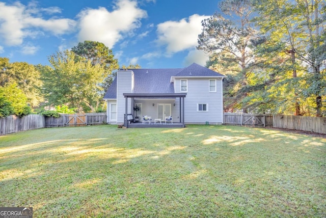 rear view of house featuring a patio, a fenced backyard, a chimney, a yard, and french doors