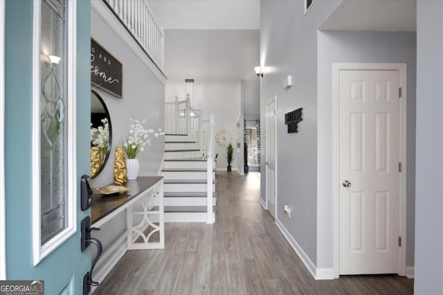 foyer with visible vents, stairs, baseboards, and wood finished floors