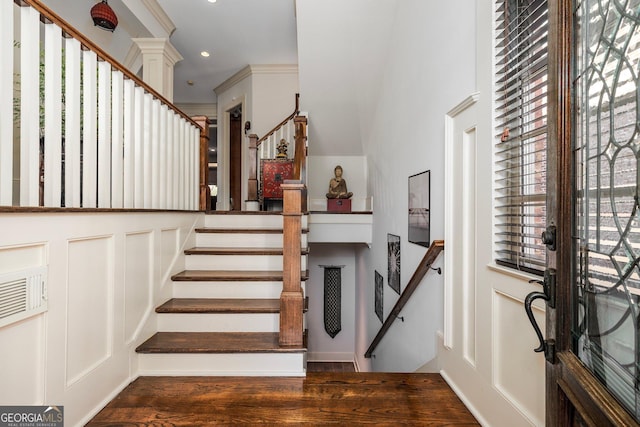 foyer with stairway, wood finished floors, crown molding, a decorative wall, and recessed lighting