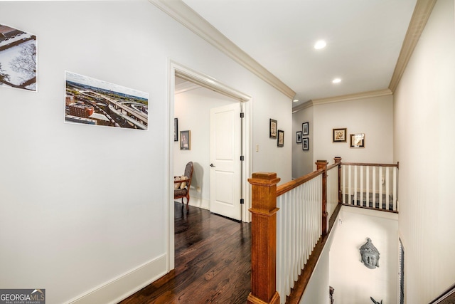 hallway featuring baseboards, ornamental molding, dark wood-type flooring, an upstairs landing, and recessed lighting