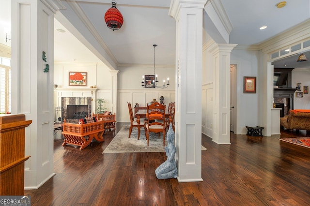 dining room with ornamental molding, a fireplace, and decorative columns