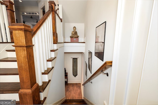 staircase with baseboards and wood finished floors