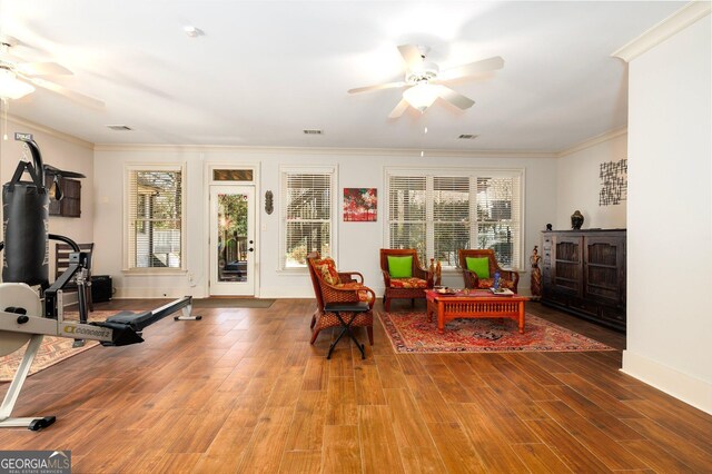 sitting room featuring ceiling fan, visible vents, crown molding, and wood finished floors