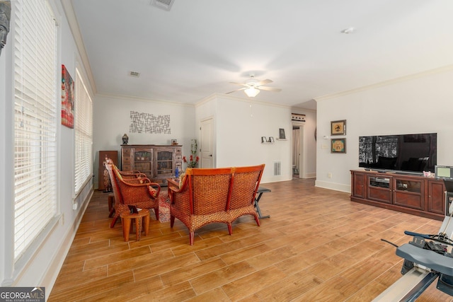 interior space with crown molding, light wood-style flooring, and ceiling fan