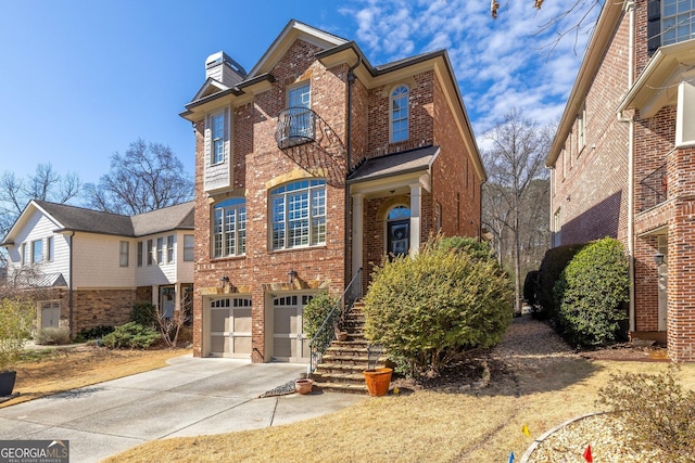 view of front facade with an attached garage, brick siding, stairs, concrete driveway, and a chimney