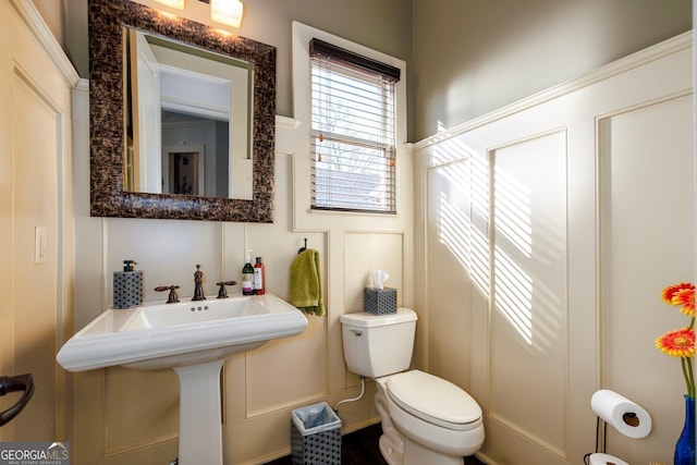 bathroom featuring toilet and a decorative wall