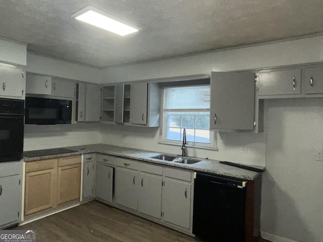 kitchen with dark wood-style floors, a sink, and black appliances