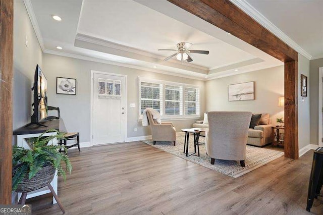 living room featuring a ceiling fan, wood finished floors, baseboards, recessed lighting, and a raised ceiling