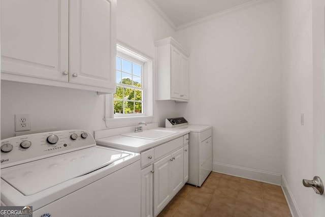 clothes washing area with crown molding, washer and clothes dryer, cabinet space, a sink, and baseboards