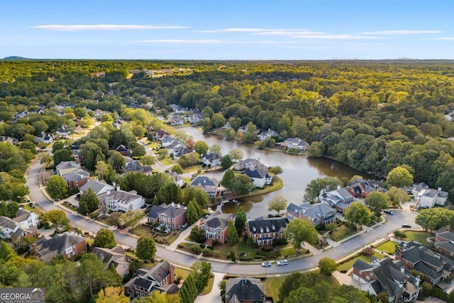 birds eye view of property featuring a residential view, a water view, and a wooded view