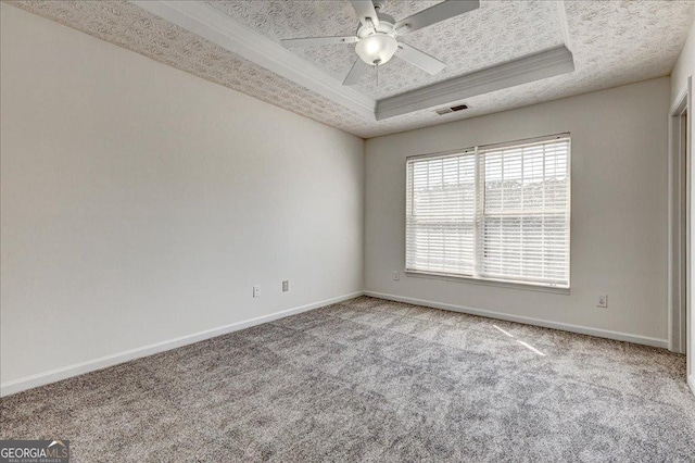 spare room featuring carpet, a raised ceiling, visible vents, a textured ceiling, and baseboards