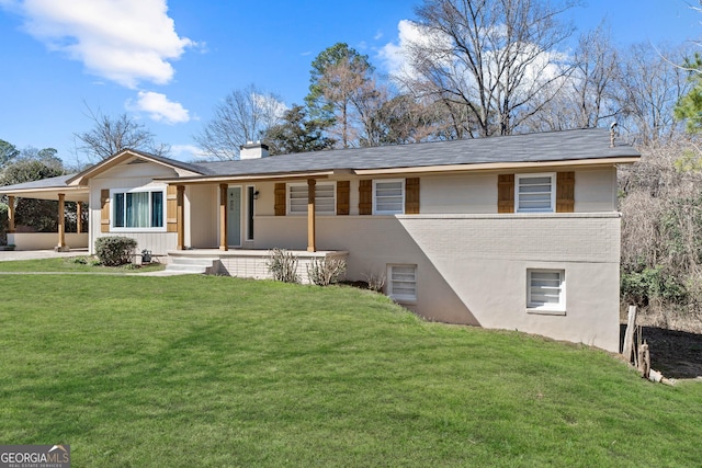 view of front of property with a porch, brick siding, a carport, a front lawn, and a chimney