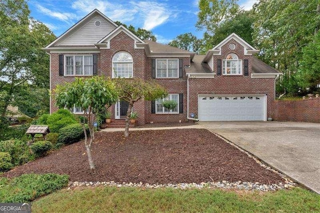 view of front facade featuring a garage, brick siding, and driveway