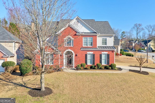 view of front of home featuring a standing seam roof, metal roof, brick siding, and a front lawn