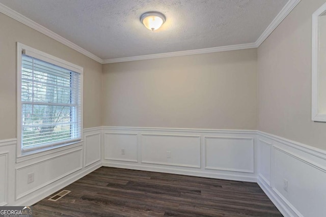 spare room featuring a textured ceiling, a wainscoted wall, dark wood-style flooring, visible vents, and ornamental molding