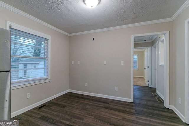 unfurnished room with a textured ceiling, ornamental molding, dark wood finished floors, and baseboards