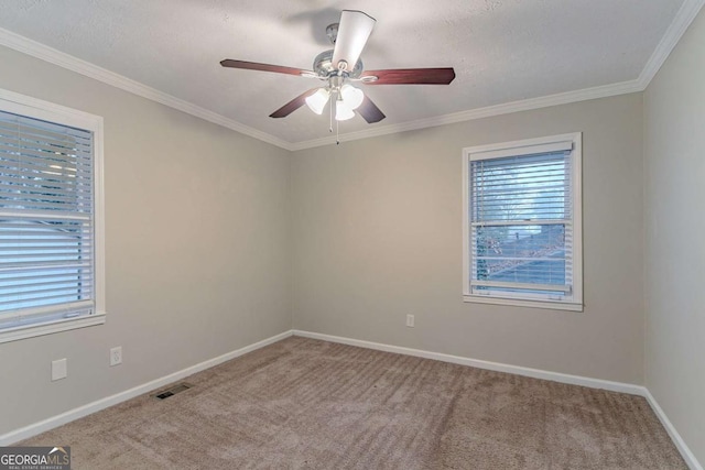 unfurnished room featuring visible vents, baseboards, ceiling fan, ornamental molding, and carpet