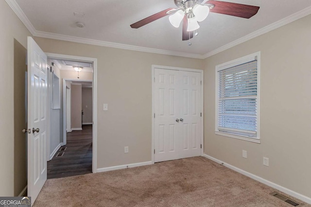 unfurnished bedroom featuring carpet floors, crown molding, visible vents, attic access, and baseboards