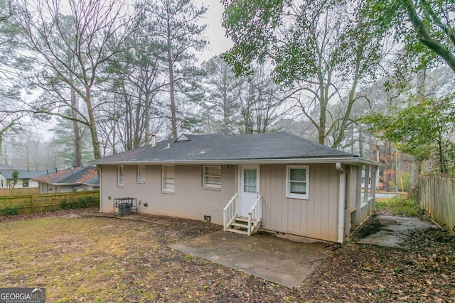 back of property with entry steps, central AC unit, fence private yard, brick siding, and crawl space