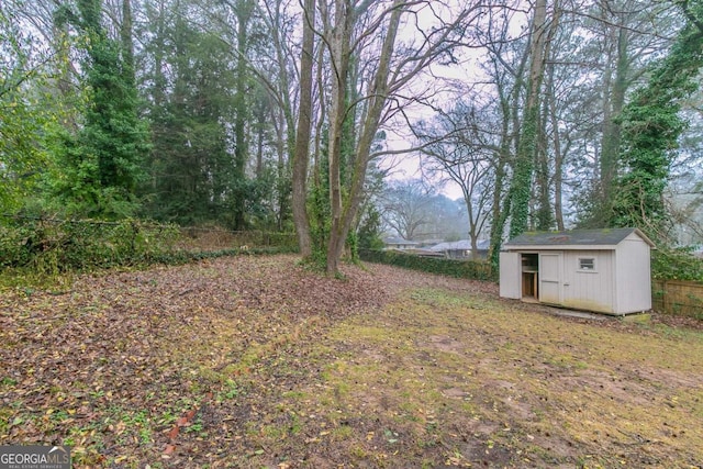 view of yard with a shed, fence, and an outdoor structure