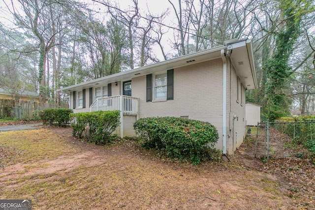 view of front of home featuring fence and brick siding