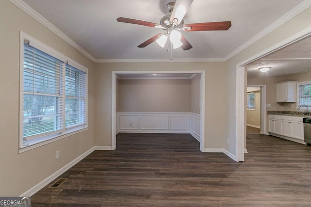 unfurnished dining area with dark wood-style floors, visible vents, ornamental molding, and a ceiling fan