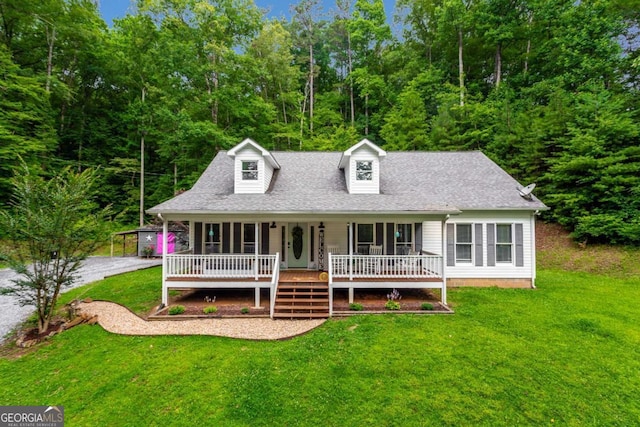 cape cod-style house featuring covered porch, roof with shingles, and a front yard